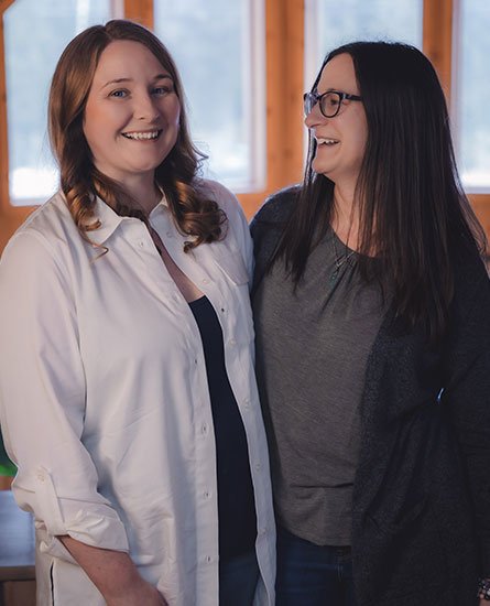 A potted plant is in the foreground and behind is a laptop with an online Reiki training class filled with students open on the screen.